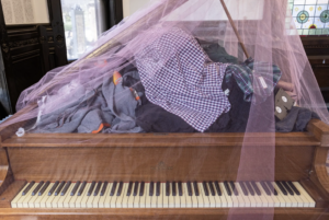 Closeup of clothing atop a piano, all part of Adam Tendler's Exit Strategy